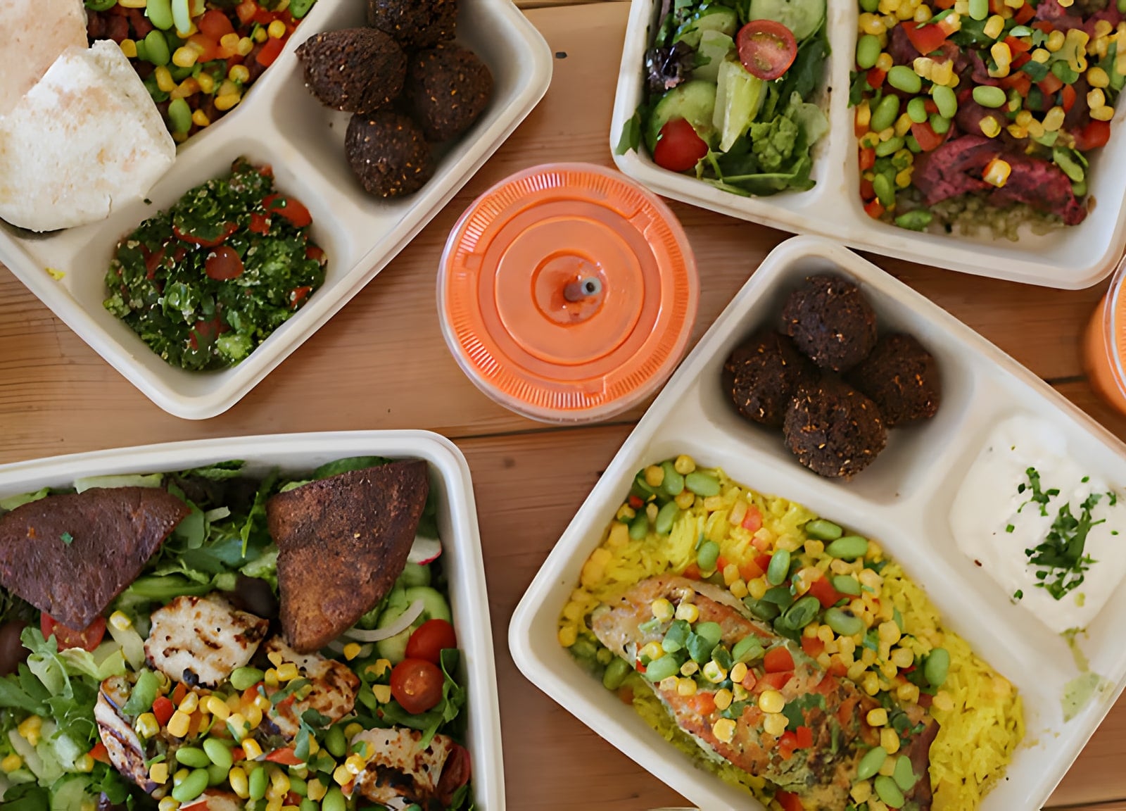 Falafel, tabbouleh, and grilled chicken plates served in compostable fiber trays